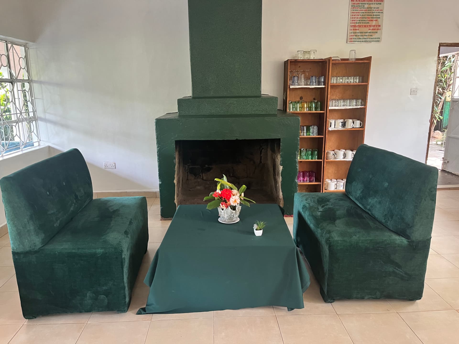 Lounge seating with green sofas beside the fireplace
